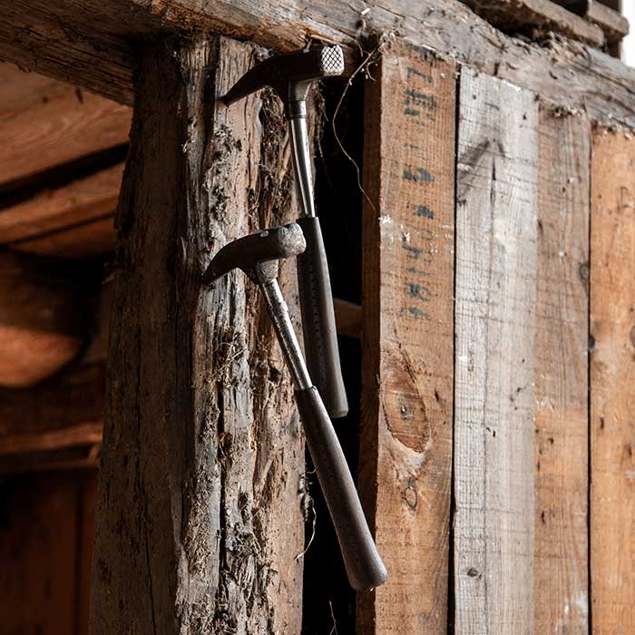 Zimmermanns Hammer steckt in altem Holzbalken