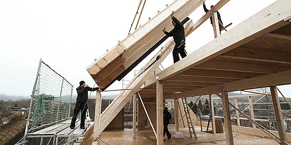 Großes Dachelement wird von einem Kran in Position gehoben