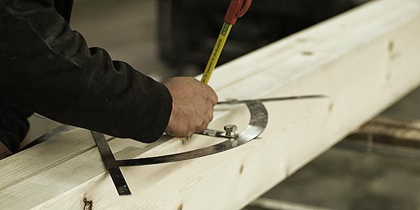 Zimmermann beim anreißen mit einem Zimmermannswinkel